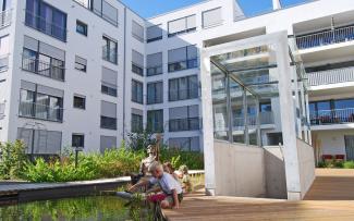 Even water features can be installed on the roof of an underground car park provided the structural capacity and design height are sufficient Children sitting at a pond in front of the staircase leading to the underground car park